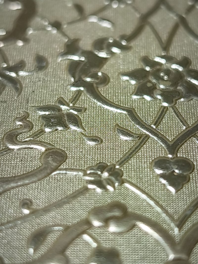 Macro detail of deep floral relief embossing on leather, showing clean shoulders