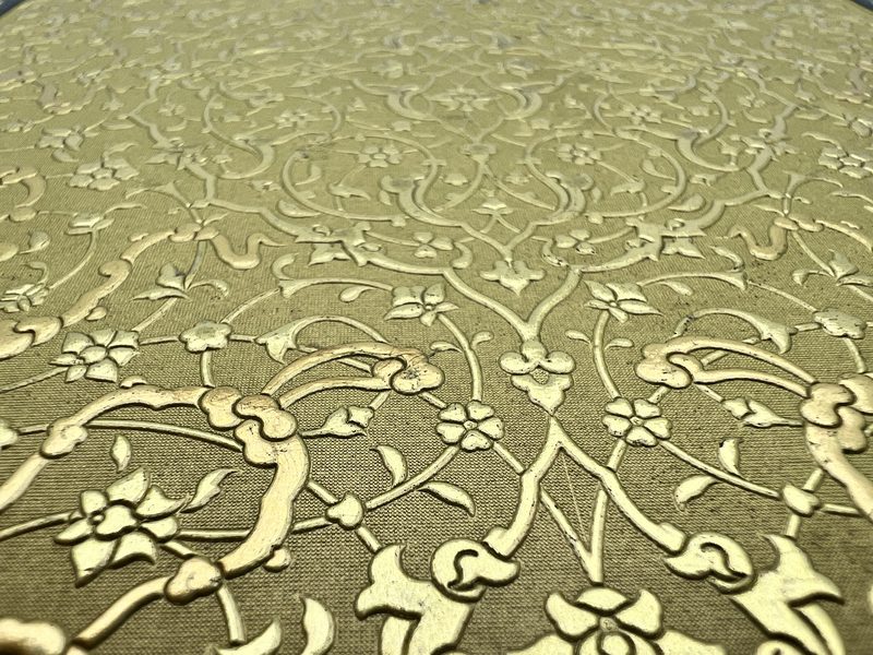 Macro of gold hot-foil over dense Islimi tooling